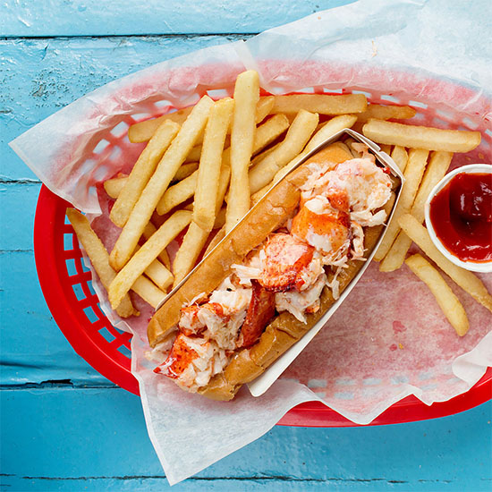 lobster roll in basket with fries